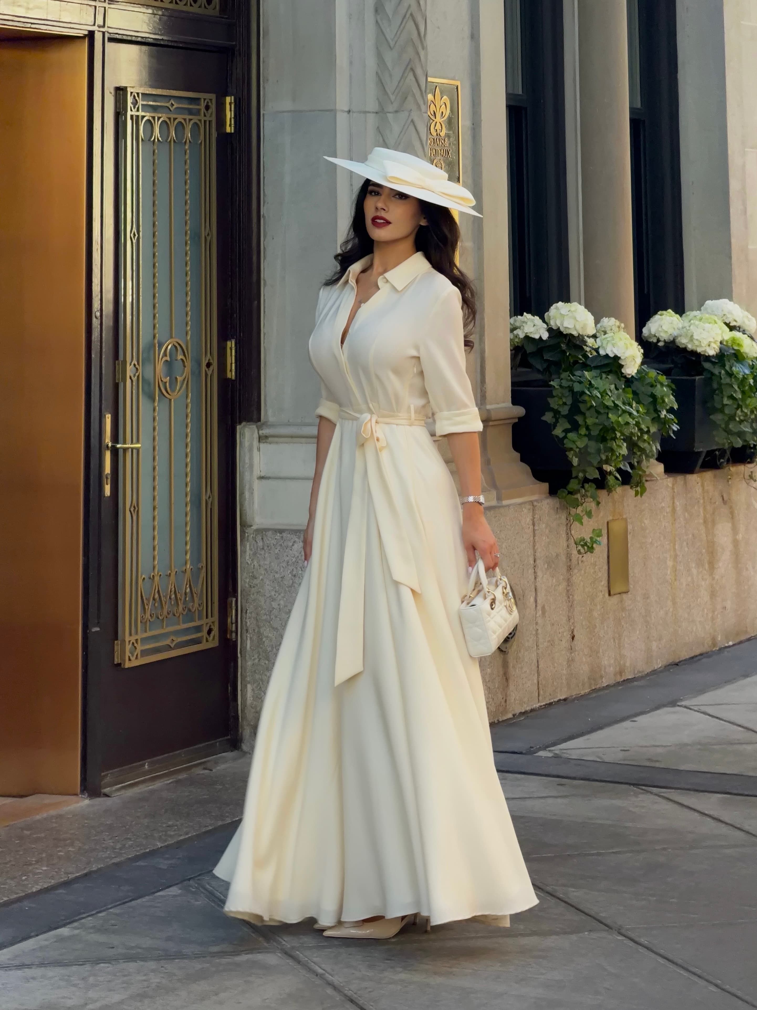 Chryssa Handis in an ivory dress and statement hat in New York City